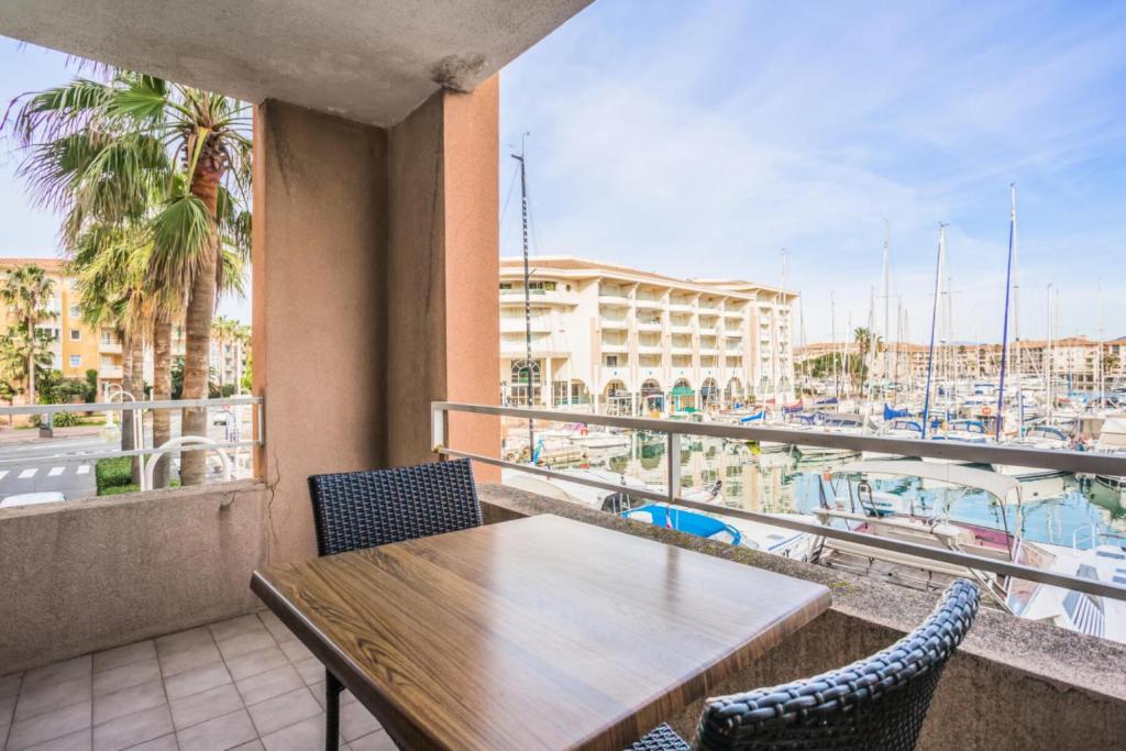 un balcon avec une table et des chaises et un port de plaisance dans l'établissement Résidence Cap Hermes - maeva Home - Studio 3 Personnes - Selection MAE-0326, à Fréjus