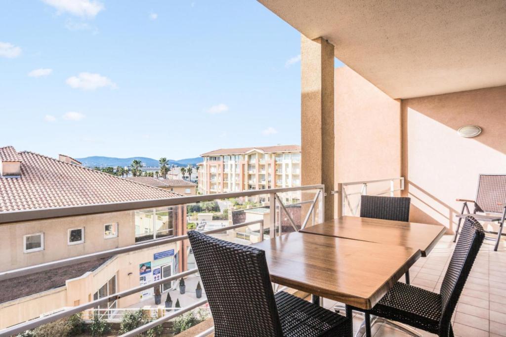 d'un balcon avec une table et des chaises en bois. dans l'établissement Résidence Cap Hermes - maeva Home - Appartement 2 Pièces 6 Personnes - Selection MAE-0325, à Fréjus
