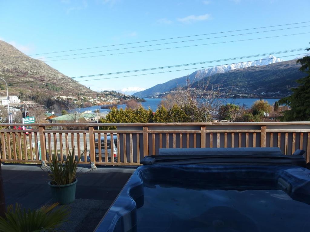 a bed on a balcony with a view of a lake at Spa B&B in Queenstown