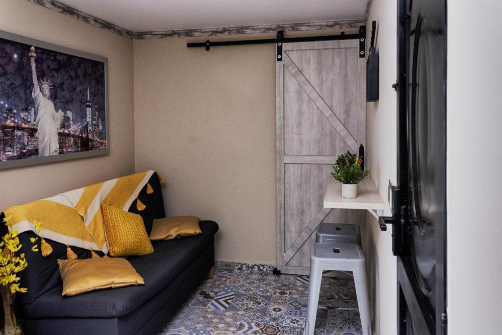 uma sala de estar com um sofá preto e uma porta de correr em Confortable apartamento en Bello Ant. em Bello