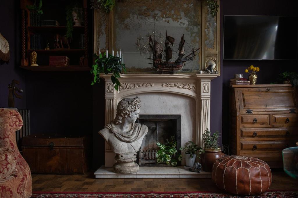 a fireplace with a statue in a living room at Flawsome Stays Unique Home w Quirky basement for 12 Guests by Harbour and Town in Ramsgate