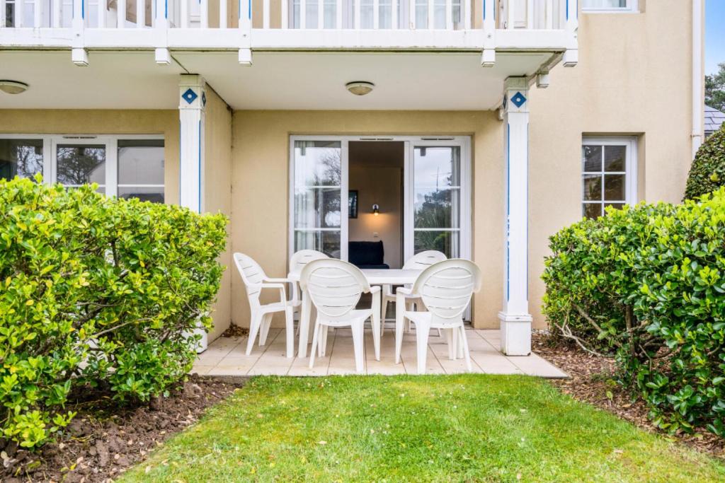 une terrasse avec une table et des chaises dans une maison dans l'établissement Résidence Cap Azur - maeva Home - Appartement 3 Pièces 7 Personnes - Confort MAE-4376, à Fouesnant