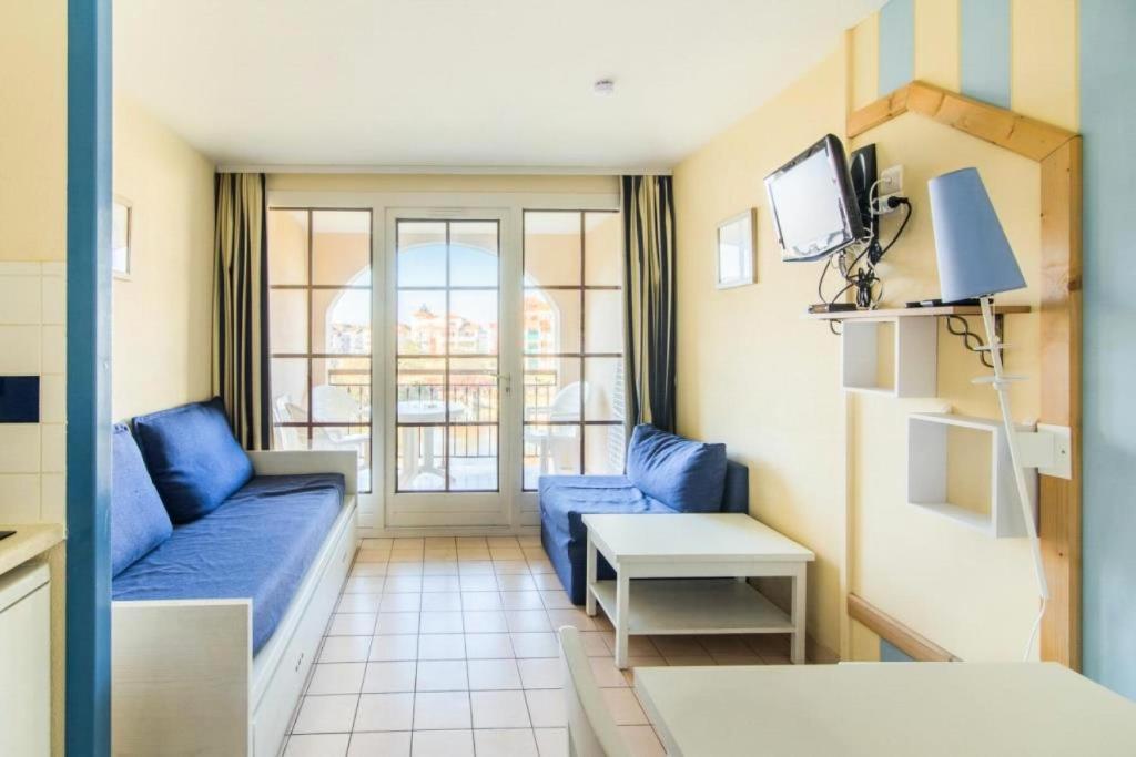un salon avec un canapé bleu et une télévision dans l'établissement Résidence Port Bourgenay - maeva Home - Studio 5 Personnes Sélection MAE-2312, à Talmont-Saint-Hilaire