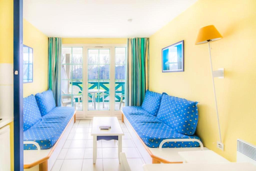 een woonkamer met blauwe banken en een tafel bij Résidence Port Bourgenay - maeva Home - 2 Pièces 5 Personnes Confort 10 in Talmont