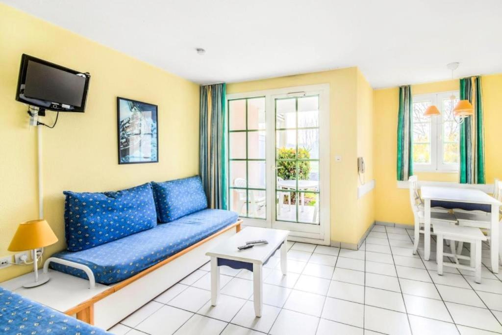 un salon avec un canapé bleu et une télévision dans l'établissement Résidence Port Bourgenay - maeva Home - 2 Pièces 5 Personnes Confort MAE-1078, à Talmont-Saint-Hilaire