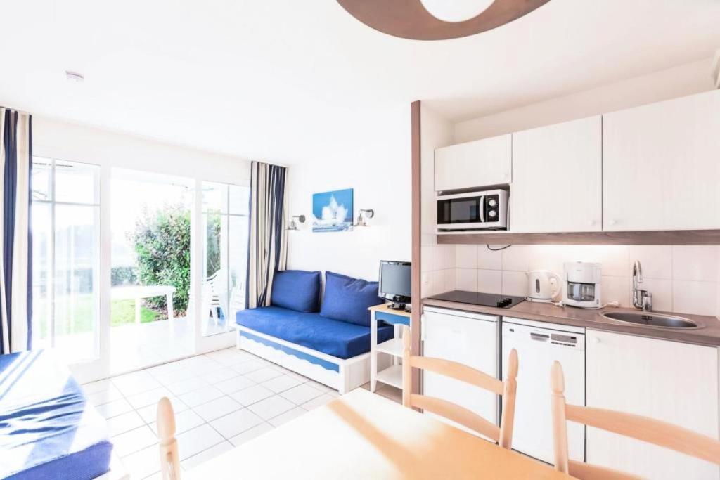 - une cuisine avec un canapé bleu dans une chambre dans l'établissement Résidence Port Bourgenay - maeva Home - 2 Pièces 5 Personnes Sélection MAE-2102, à Talmont-Saint-Hilaire