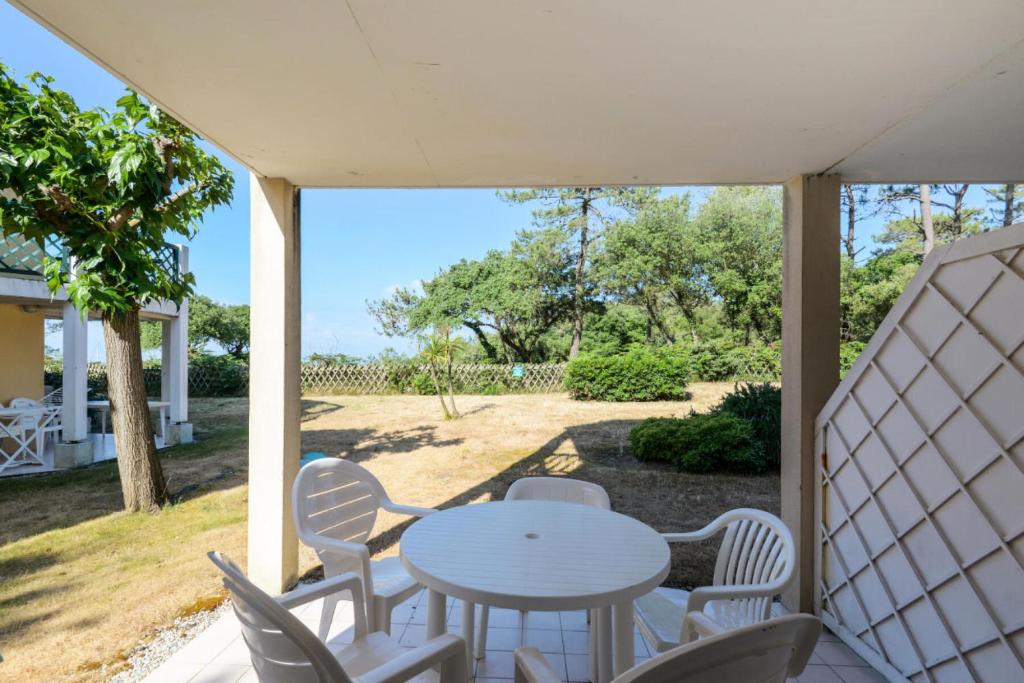 une terrasse couverte avec une table blanche et des chaises. dans l'établissement Résidence Port Bourgenay - maeva Home - Appartement 2 pièces 5 personnes - Sélection MAE-2048, à Talmont-Saint-Hilaire