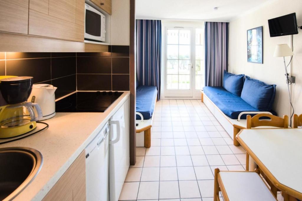 une cuisine et un salon avec un canapé dans une pièce dans l'établissement Résidence Port Bourgenay - maeva Home - 2 Pièces 5 Personnes Sélection MAE-2053, à Talmont-Saint-Hilaire