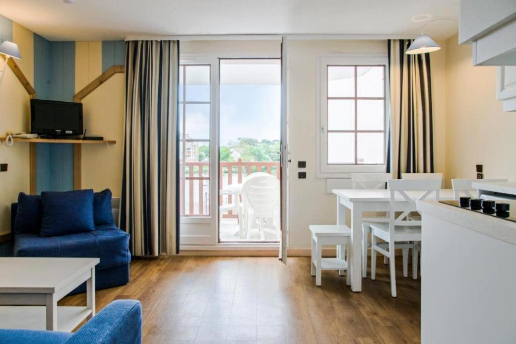 une cuisine et un salon avec une table et des chaises dans l'établissement Résidence Port Bourgenay - maeva Home - Appartement 2 Pièces 5 Personnes - Sélection MAE-9029, à Talmont-Saint-Hilaire