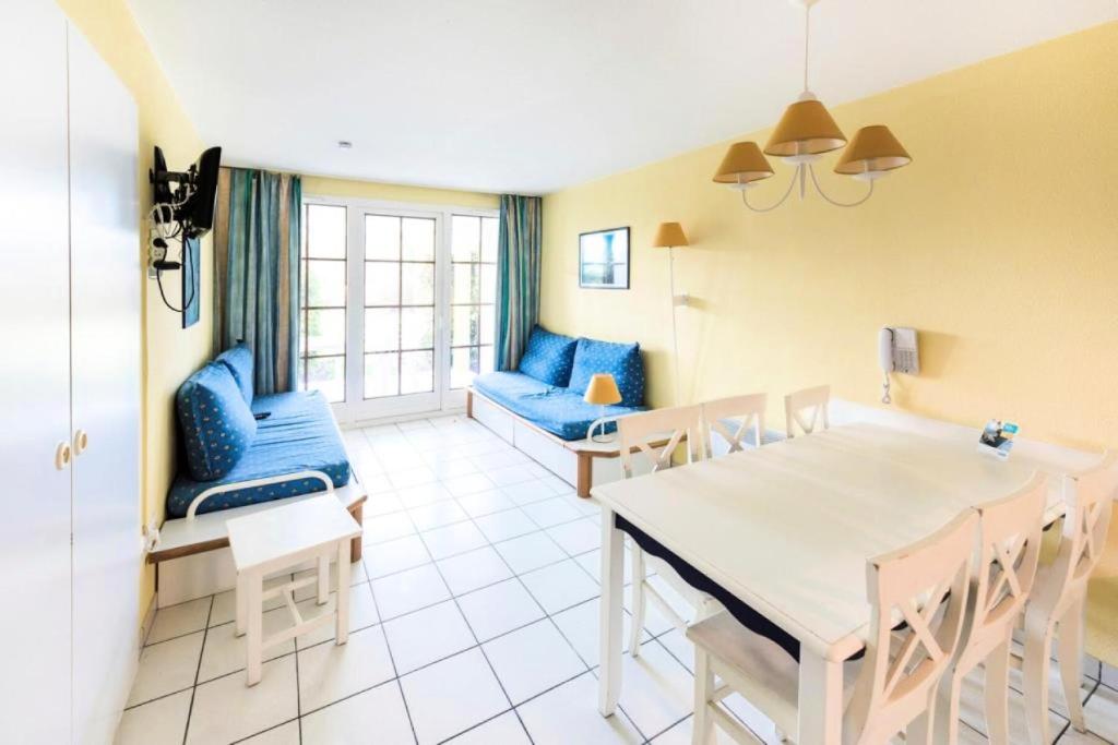 une cuisine et une salle à manger avec une table et des chaises dans l'établissement Résidence Port Bourgenay - maeva Home - Appartement 2 Pièces 7 Personnes - Confort MAE-2206, à Talmont-Saint-Hilaire
