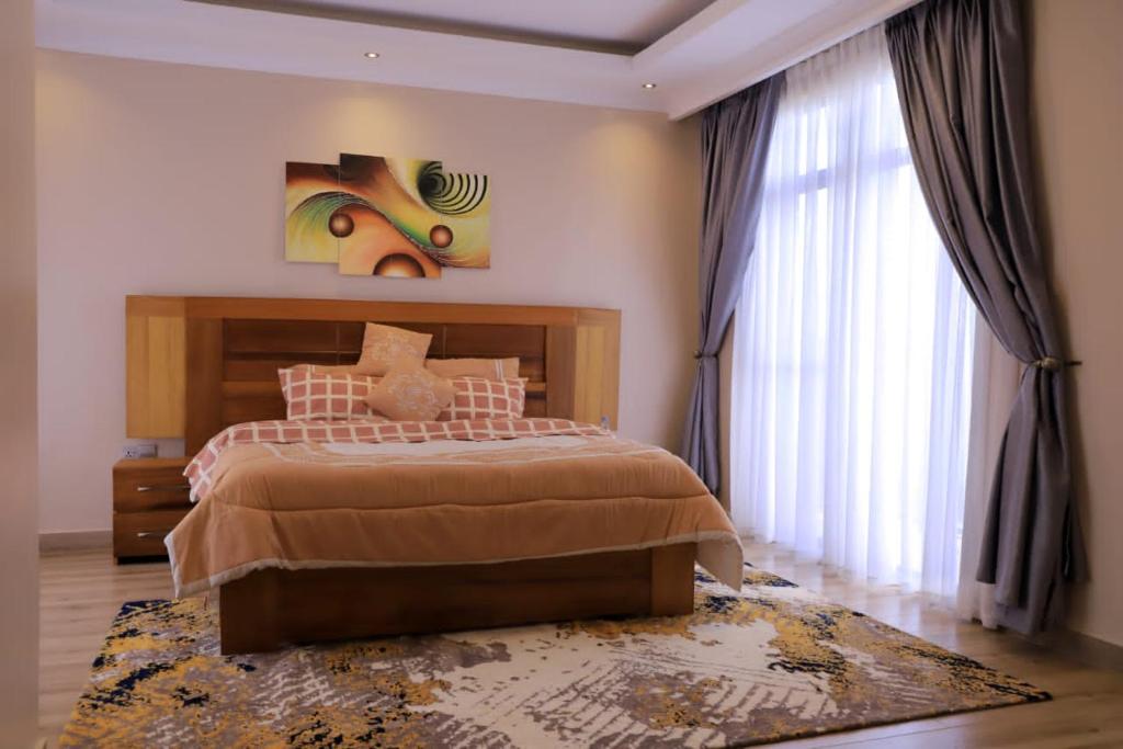 um quarto com uma cama e um quadro na parede em Didy d’Or Lounge em Kigali