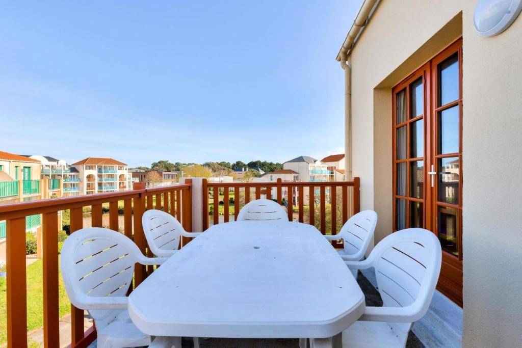 une table blanche et des chaises sur un balcon dans l'établissement Résidence Port Bourgenay - maeva Home - 2 Pièces 7 Personnes - Sélection MAE-4662, à Talmont-Saint-Hilaire
