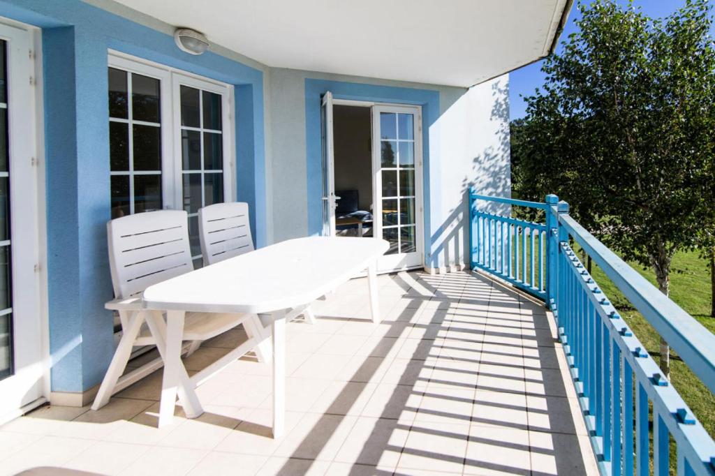 d'une table blanche et de deux chaises sur un balcon. dans l'établissement Résidence Port Bourgenay - maeva Home - 2 Pièces 7 Personnes Sélection MAE-1442, à Talmont-Saint-Hilaire