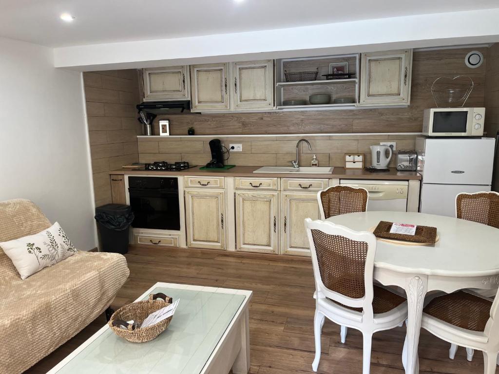 ein Wohnzimmer mit einem Tisch und einer Küche in der Unterkunft L'intemporel 