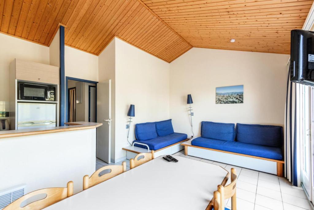- un salon avec un mobilier bleu dans une maison dans l'établissement Résidence Port Bourgenay - maeva Home - 3 Pièces 7 Personnes Sélection MAE-7834, à Talmont-Saint-Hilaire