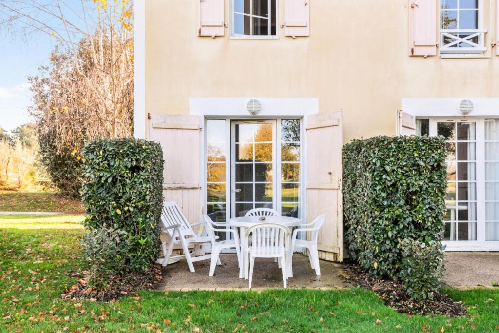 une table et des chaises devant une maison dans l'établissement Les Maisons de Port Bourgenay - maeva Home - Maison 2 Pièces 5 Personnes Selection MAE-4485, à Talmont-Saint-Hilaire