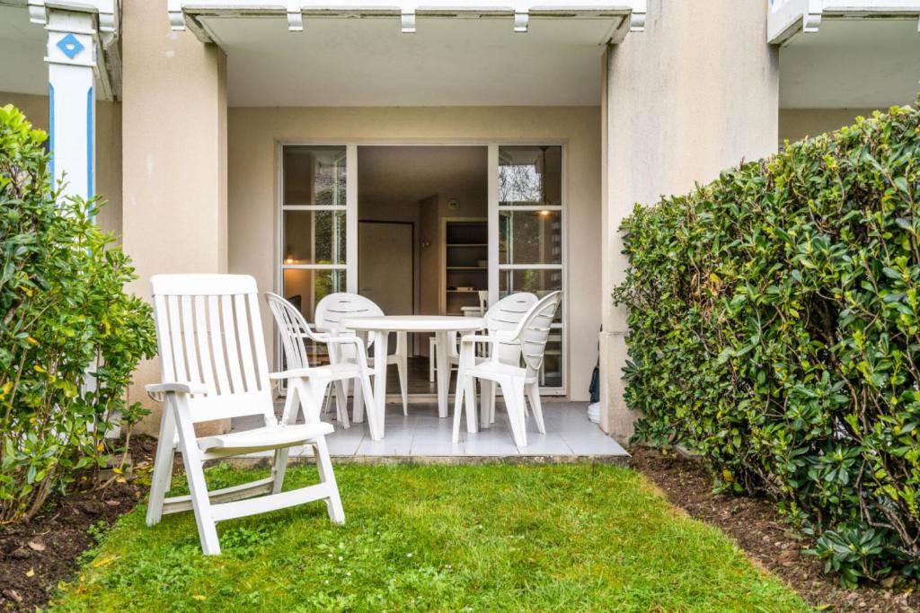 d'une terrasse avec des chaises blanches et une table. dans l'établissement Le Cap Glénan - maeva Home - Appartement 2 Pièces 4 Personnes - Confort 43, à Bénodet