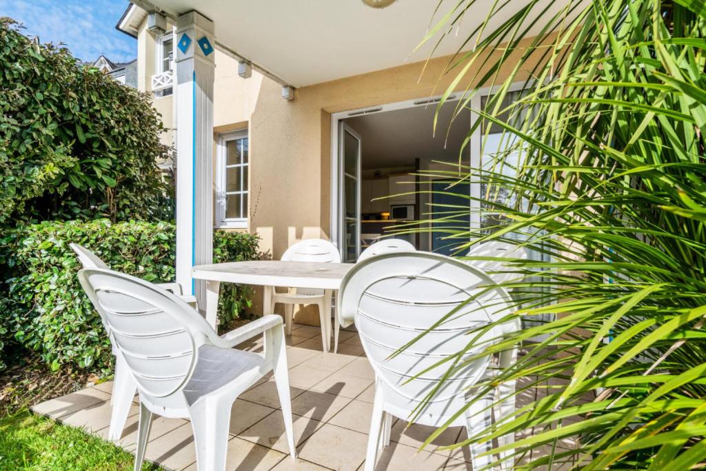 eine Terrasse mit weißen Stühlen und einem Tisch in der Unterkunft Résidence Cap Azur - maeva Home - Appartement 3 Pièces 7 Personnes - Confor 80 in Fouesnant