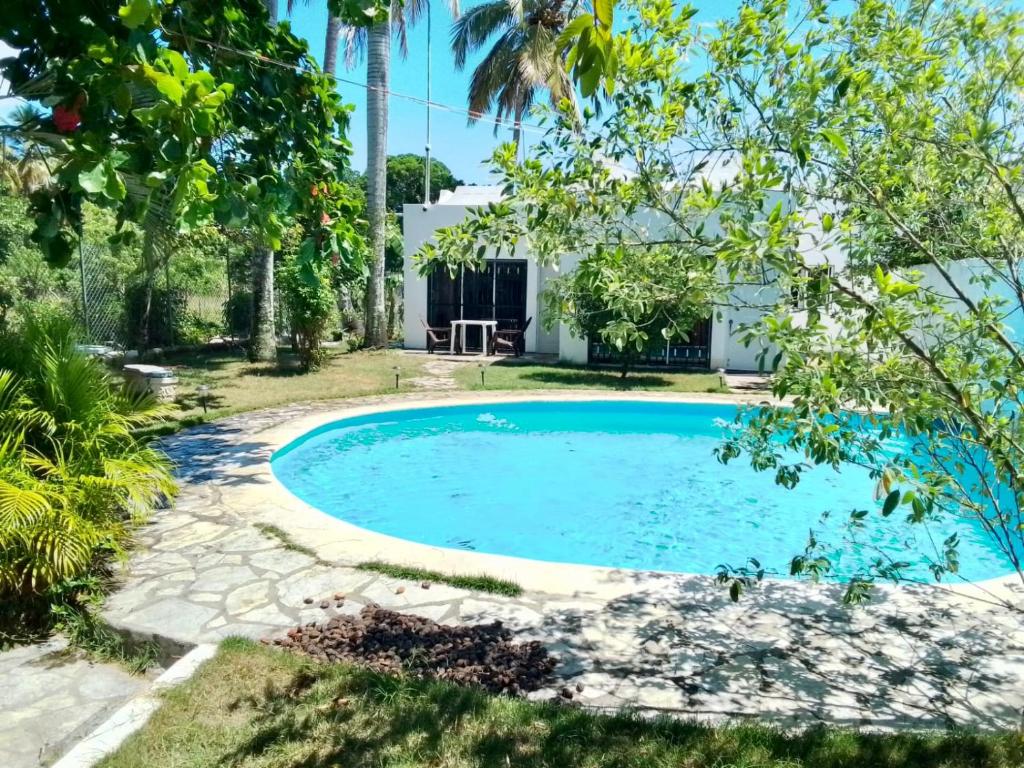 een zwembad in de achtertuin van een huis met bomen bij Sea Grape apartments in Cabarete