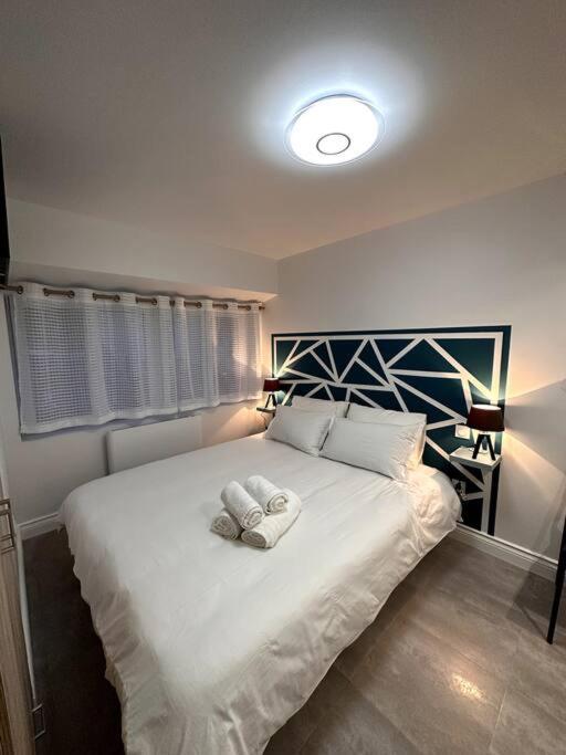 een slaapkamer met een groot wit bed en 2 handdoeken bij studio 2 au cœur de Périgueux in Périgueux