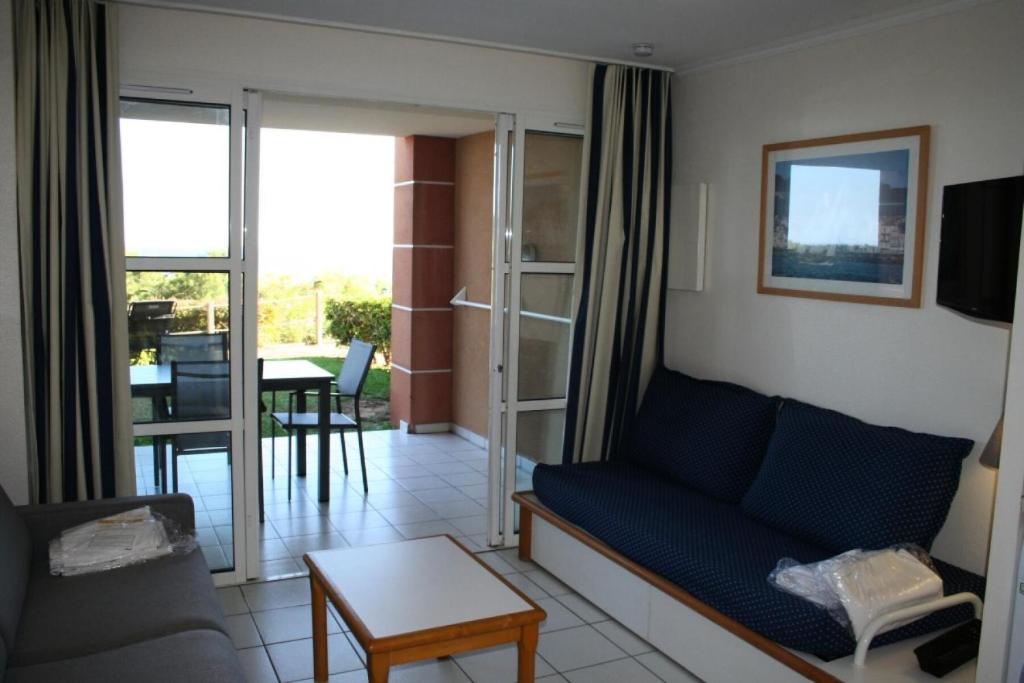 un salon avec un canapé et une table dans l'établissement Résidence le Hameau de Cap Esterel - maeva Home - Appartement 2 Pièces 5 Personnes - Sélection MAE-5802, à Saint-Raphaël