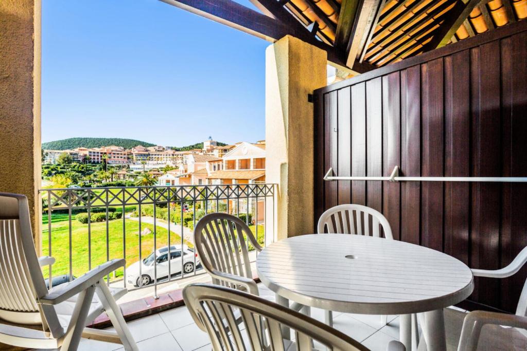 d'une table et de chaises sur un balcon avec vue sur une voiture. dans l'établissement Résidence le Village de Cap Esterel - maeva Home - Appartement 2 Pièces 5 Personnes - Confort MAE-2137, à Saint-Raphaël