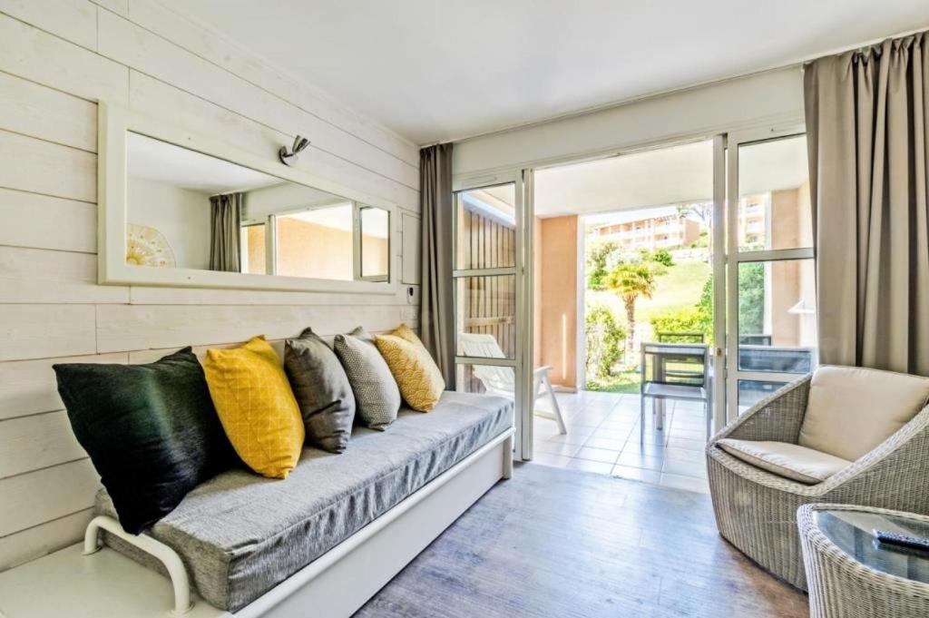 un salon avec un canapé et un miroir dans l'établissement Résidence le Village de Cap Esterel - maeva Home - Appartement cosy 2 pièces 5 personnes - Sélection - Super Home MAE-4000, à Saint-Raphaël