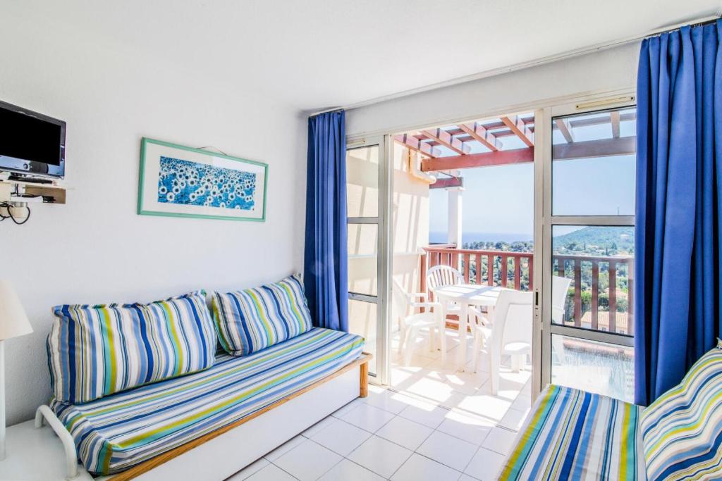 d'un salon avec un canapé et un balcon. dans l'établissement Résidence le Village de Cap Esterel - maeva Home - Appartement 2 Pièces 5 Personnes - Confort MAE-5960, à Saint-Raphaël