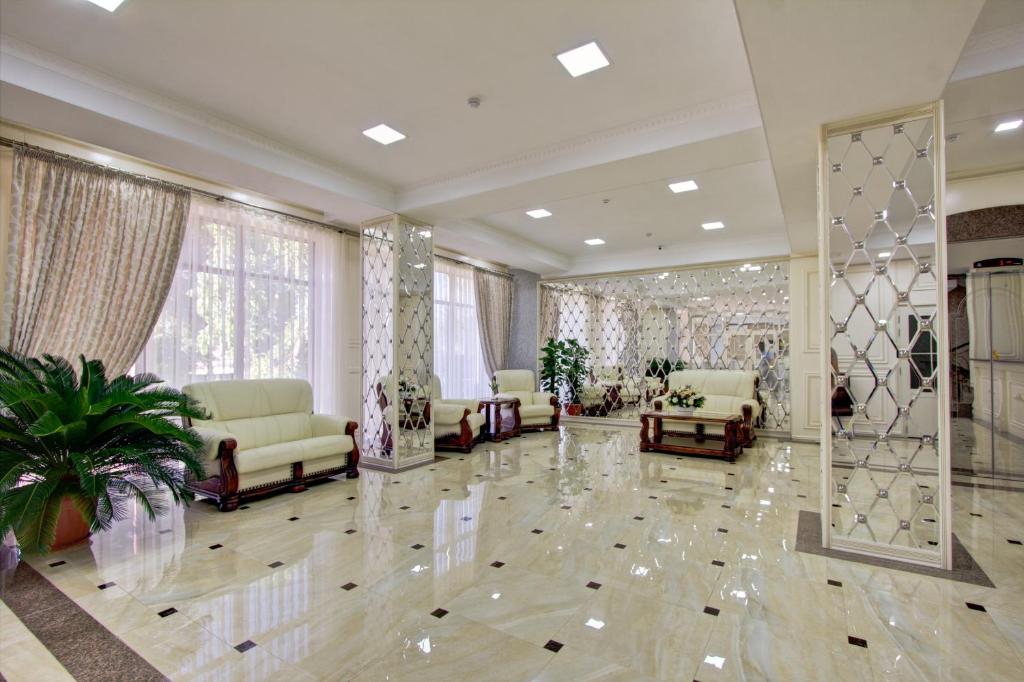een grote woonkamer met banken en een spiegel bij Discovery Hotel in Bisjkek
