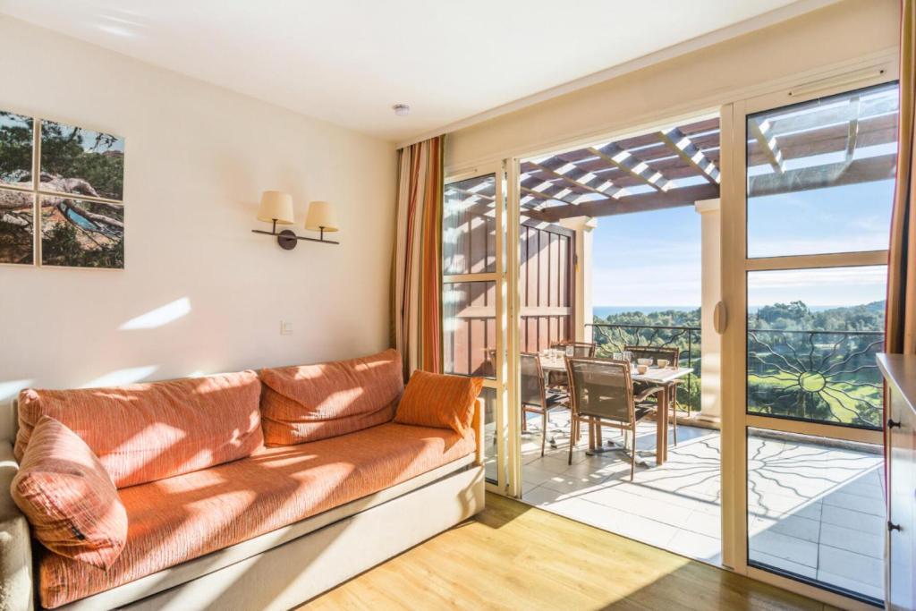 d'un salon avec un canapé et un balcon. dans l'établissement Résidence le Village de Cap Esterel - maeva Home - Appartement duplex 2 pièces 7 personnes Sélection MAE-4540, à Saint-Raphaël
