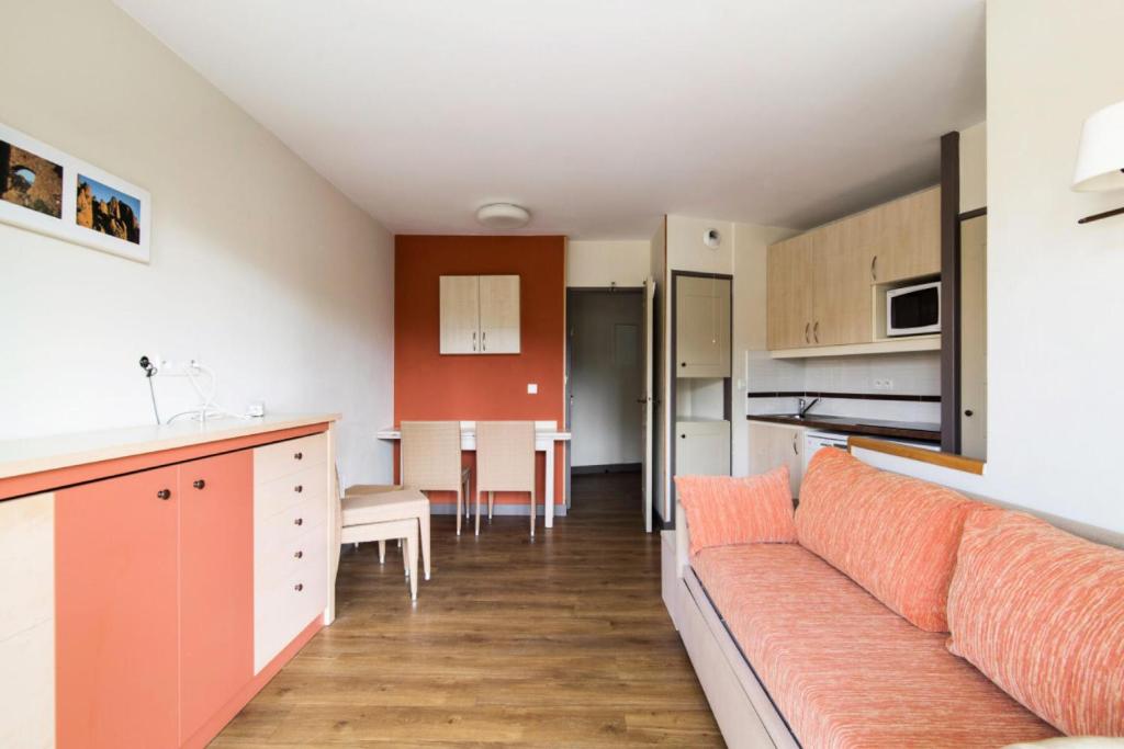 un salon et une cuisine avec un canapé et une table dans l'établissement Résidence le Village de Cap Esterel - maeva Home - Appartement 2 pièces 5 personnes - Sélection MAE-4799, à Saint-Raphaël