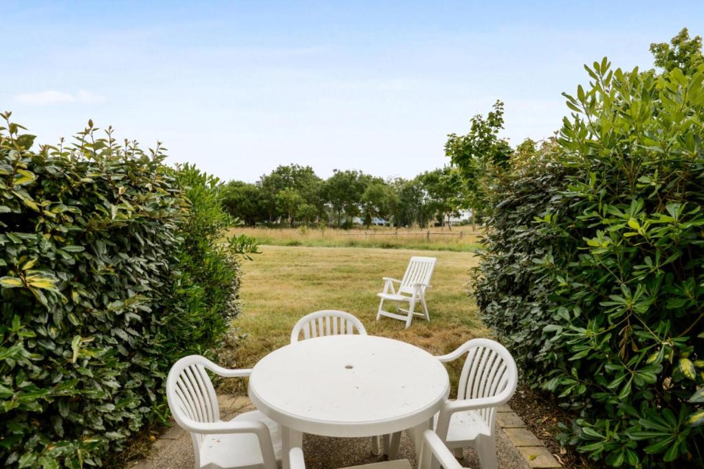 - une table et des chaises blanches dans le jardin dans l'établissement Les Maisons de Port Bourgenay - maeva Home - Maison 2 Pièces 5 Personnes - Sélection MAE-5565, à Talmont-Saint-Hilaire