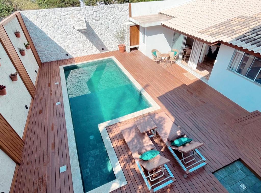 una terraza de madera con vistas a una piscina. en Casa com piscina climatizada em frente à Praia do Santinho, en Florianópolis