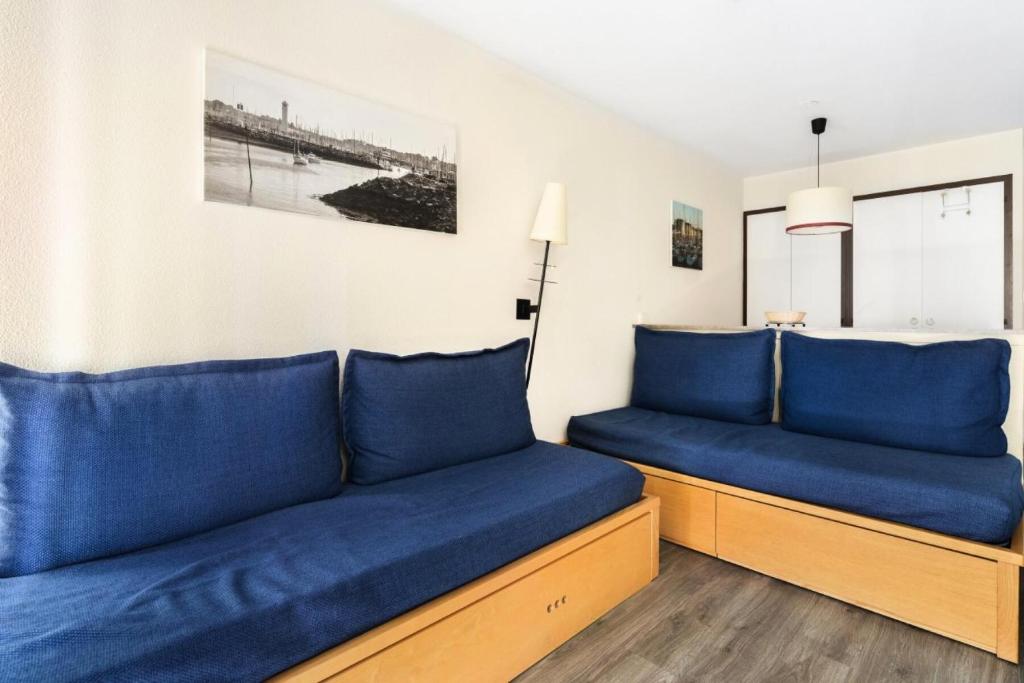 - un salon avec des oreillers bleus sur un canapé dans l'établissement Résidence Port du Crouesty - maeva Home - Appartement 2 pièces 5 personnes - Confort - Vue mer MAE-0450, à Arzon