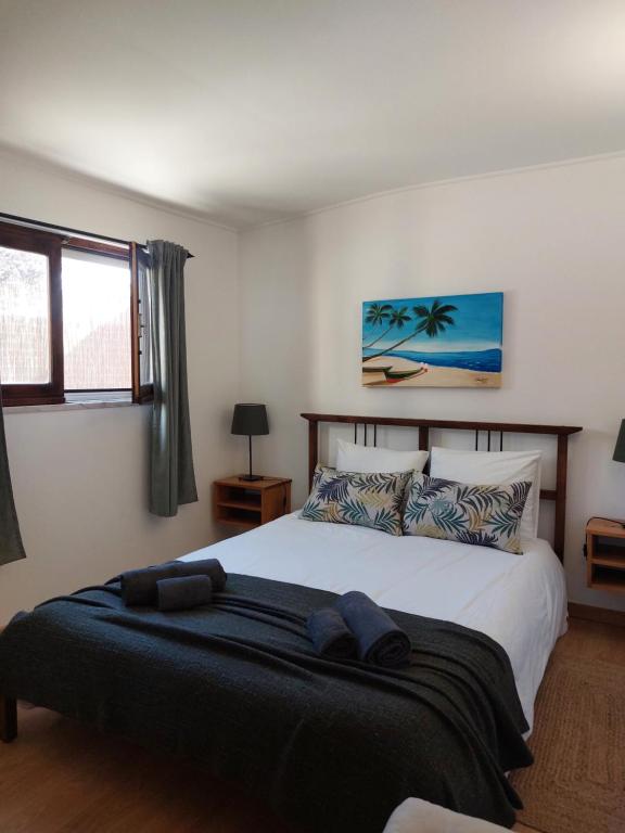 a bedroom with a large bed with a black blanket at casa do vale - Lagoa de Albufeira in Lagoa de Albufeira