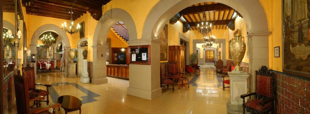 un corridoio di un edificio con archi e sala da pranzo di Hotel Posada Santa Fe a Guanajuato