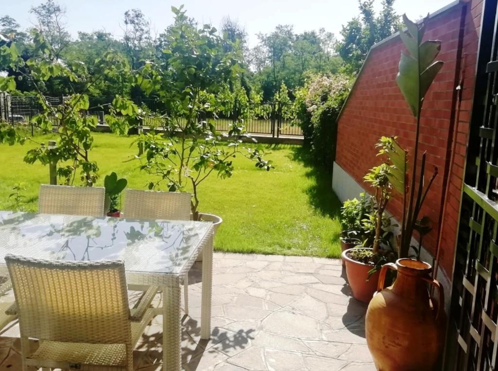 d'une terrasse avec une table et des chaises ainsi que d'un jardin. dans l'établissement Luminoso appartamento con giardino San Bovio, à Peschiera Borromeo
