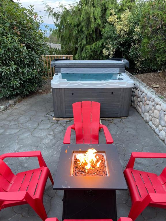 a patio with two red chairs and a hot tub at Eagle's View Penthouse in Victoria