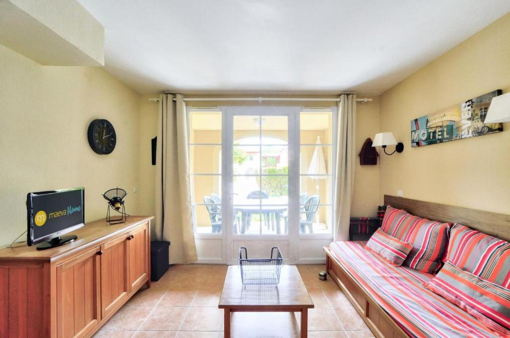 un salon avec un canapé et une télévision dans l'établissement La résidence du Lac - maeva Home - Maison 3 pièces 6 personnes Prestige MAE-6846, à Monflanquin