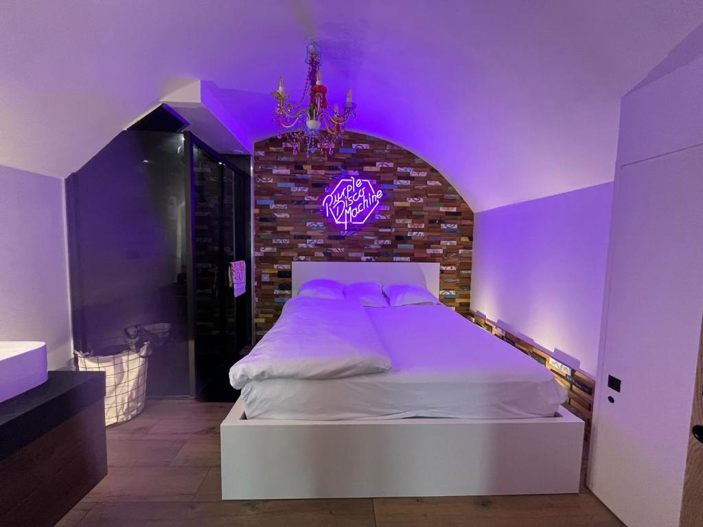 a bedroom with a bed with a purple lighting at Charmant studio - Vue panoramique lac in Meillerie