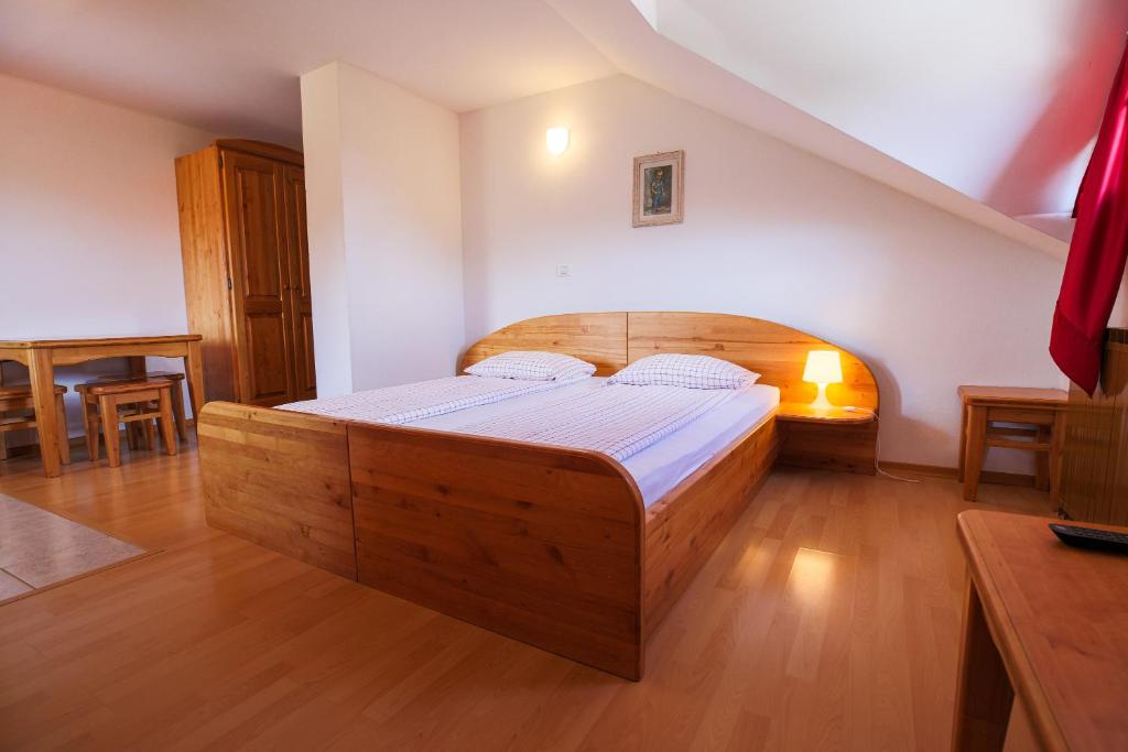 Villa Slavina的住宿－Domačija Malnarjevi，一间卧室配有一张大木床。