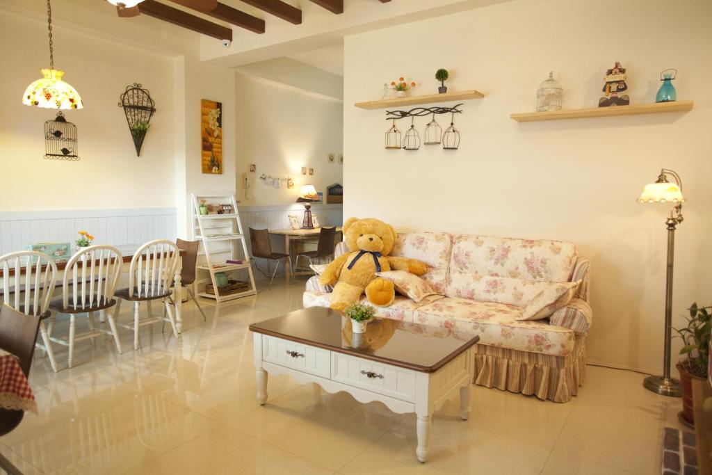 a teddy bear sitting on a couch in a living room at Blue Cotton Candy B&amp;B in Taitung City