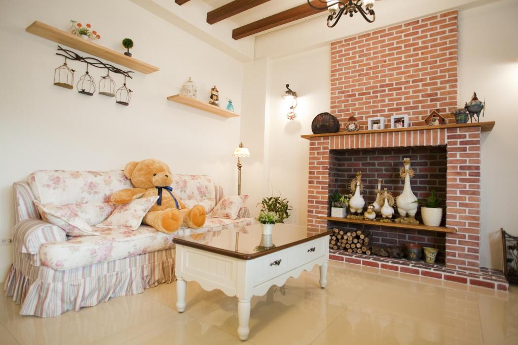 a teddy bear sitting on a chair in a living room with a fireplace at Blue Cotton Candy B&amp;B in Taitung City