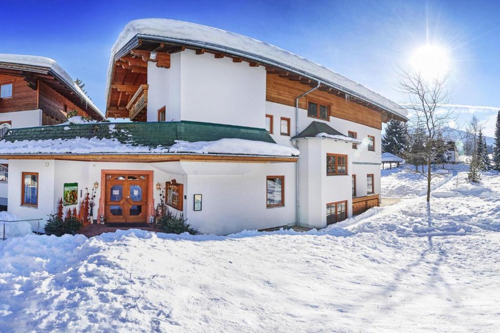 une maison avec de la neige devant elle dans l'établissement Apartment in Flachau with parking space, à Flachau