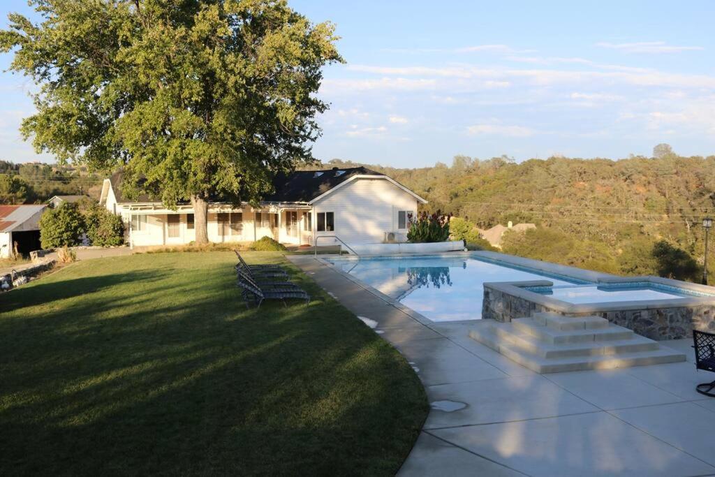 a backyard with a swimming pool and a house at 1940 Farmhouse with Pool in Newcastle