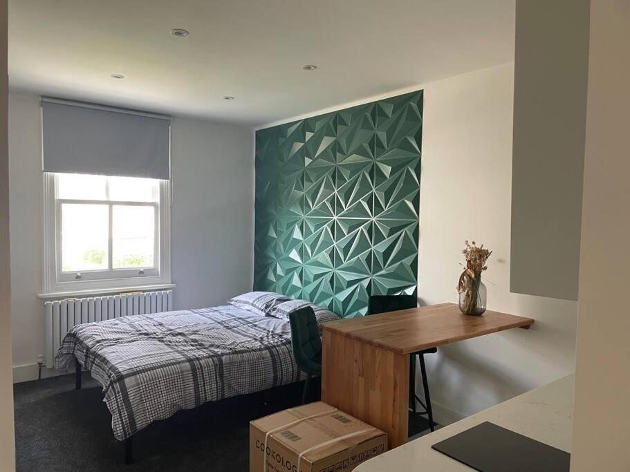 een slaapkamer met een bed, een bureau en een raam bij Studio 5 mins from the beach in Brighton & Hove