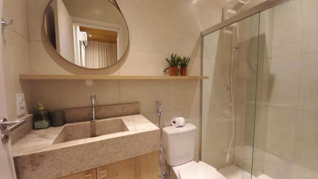 ein Badezimmer mit einem WC, einem Waschbecken und einem Spiegel in der Unterkunft Cobertura Milagres do Chef in São Miguel dos Milagres