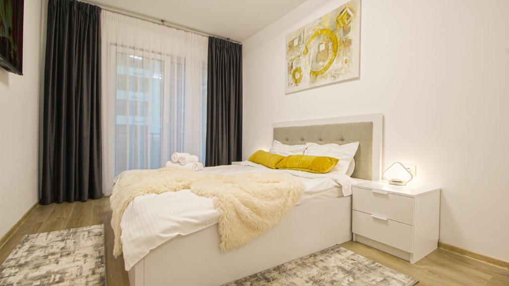 - une chambre blanche avec un lit et une fenêtre dans l'établissement MO Apartment One, à Braşov