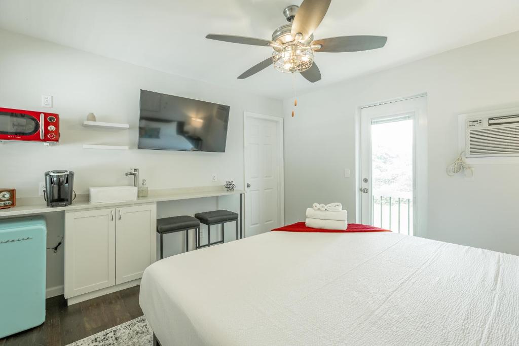 a white bedroom with a bed and a ceiling fan at 11 The Charlotte Room - A PMI Scenic City Vacation Rental in Chattanooga