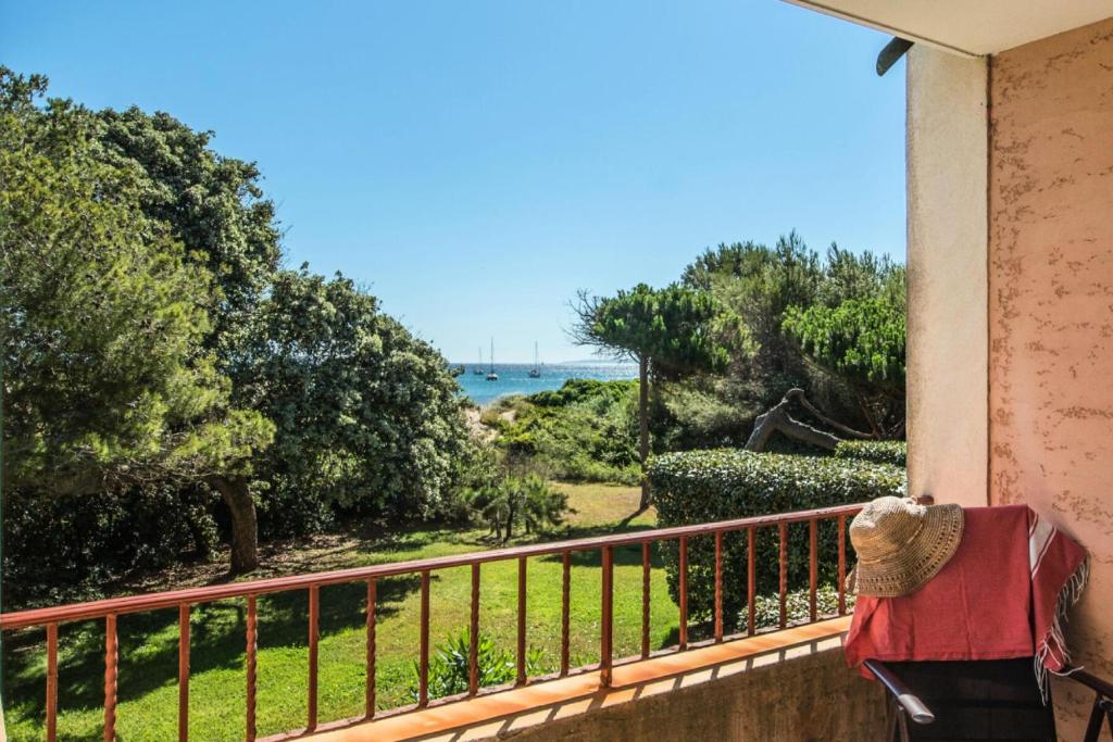 a person sitting on a balcony looking out at the ocean at Résidence La Pinède - maeva Home - Studio 4 Personnes - Sélection 19 in Hyères